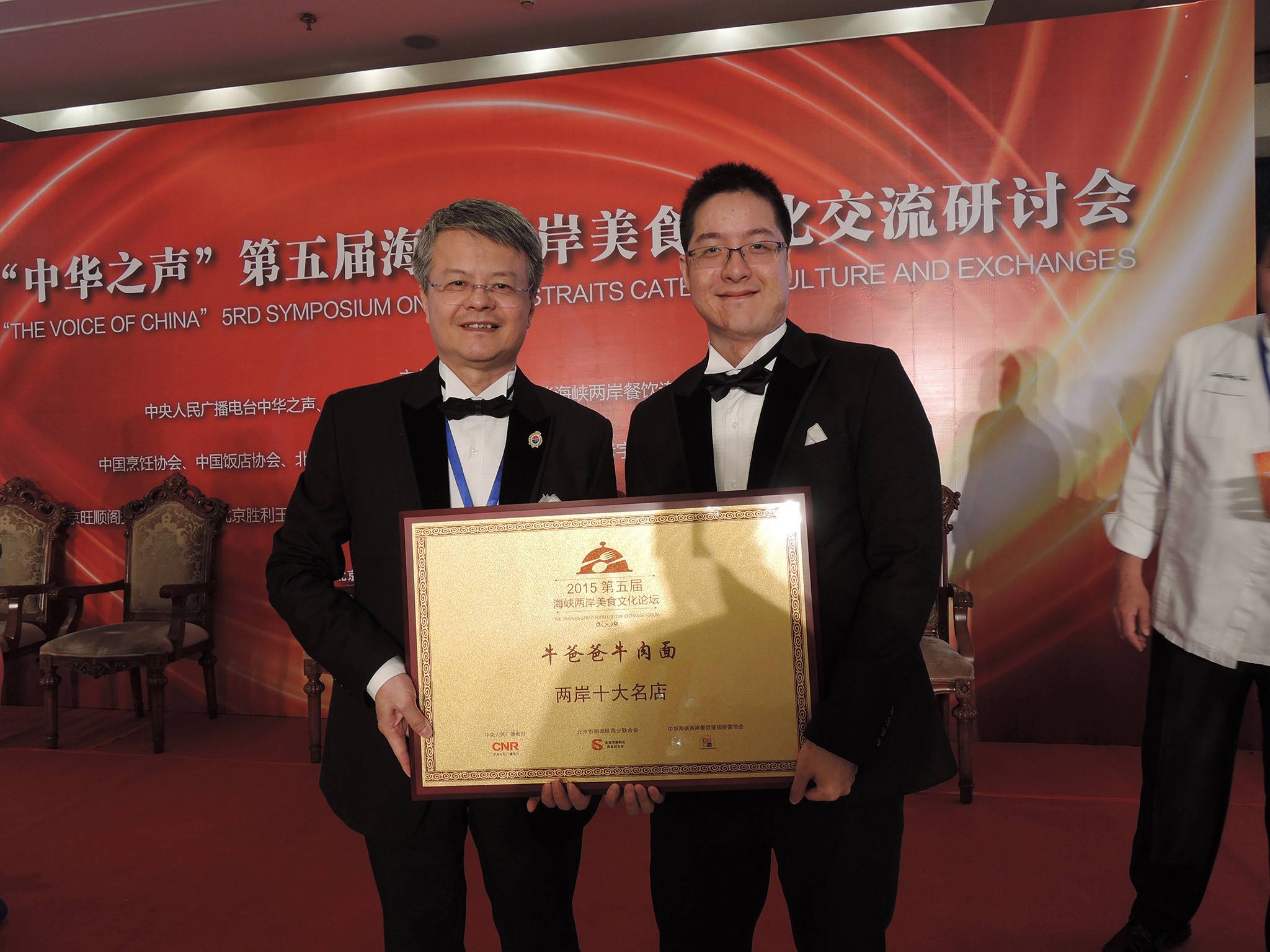 台北 牛肉麵 牛爸爸及兒子領獎的合照，店家榮獲2015第五屆海峽兩岸美食文化論壇的兩岸十大名店。