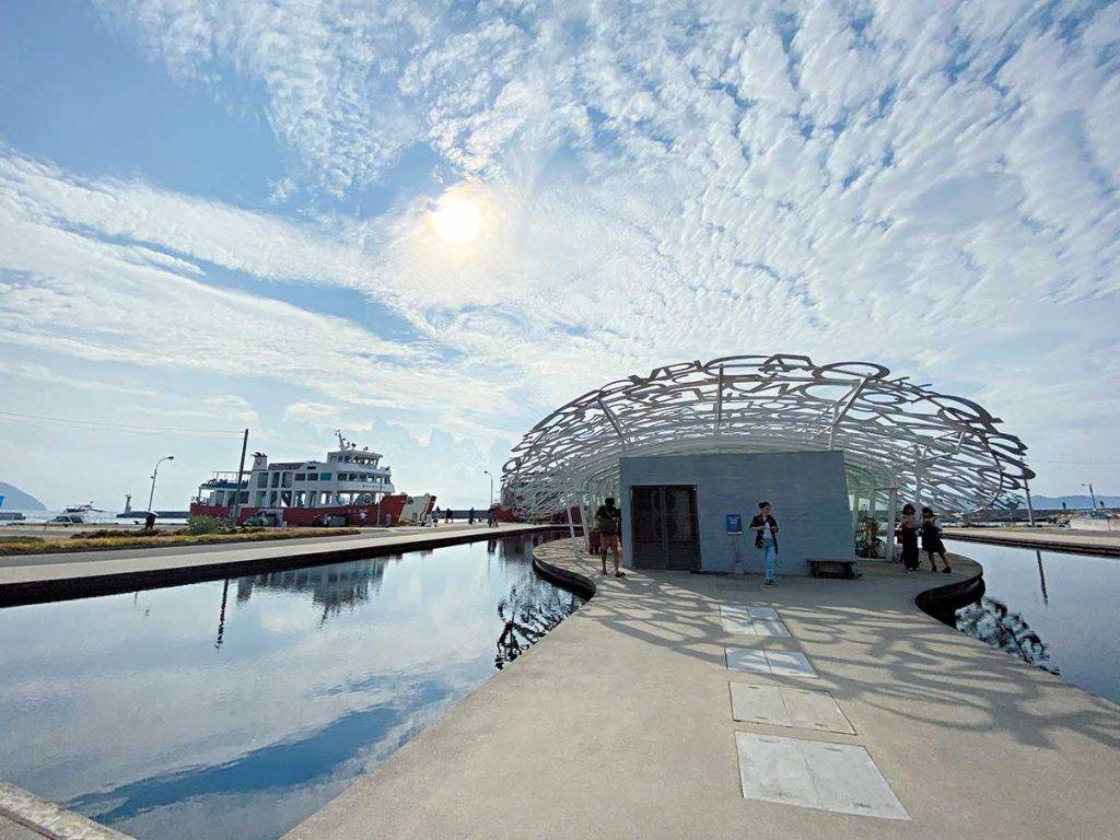四國景點 《男木島の魂》•Jaume Plensa在碼頭旁的男木港案內所，藝術家把不 同字體設計做成巨大的雕花屋頂，漂亮的倒影就像把文字刻在天空之鏡上。