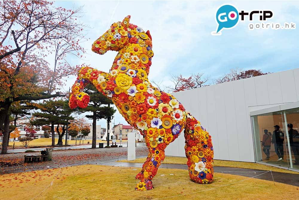 日本親子遊 藝術館位於市中心「官廳街通」，古時是舊 陸軍軍馬補充部，又名「駒街道」。此藝術 品由韓國藝術家製作，名為「 花馬 」，來表 現十和田市四季及未來繁榮開花之徵。