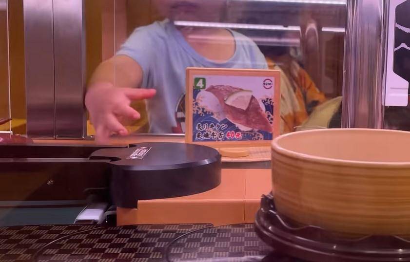 壽司郎 家長懶理 網民吃迴轉壽司時，眼見對面有一小孩伸手到塑膠擋板的隙縫玩弄食物